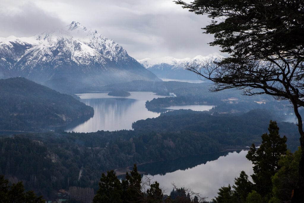 Dark clouds hang over snowy mountains and lakes in Argentina's lake district