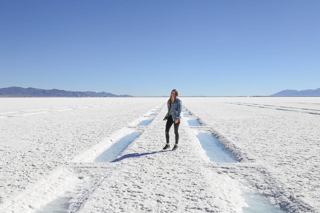 A woman walking on bright white salt in Argentina' salt flats