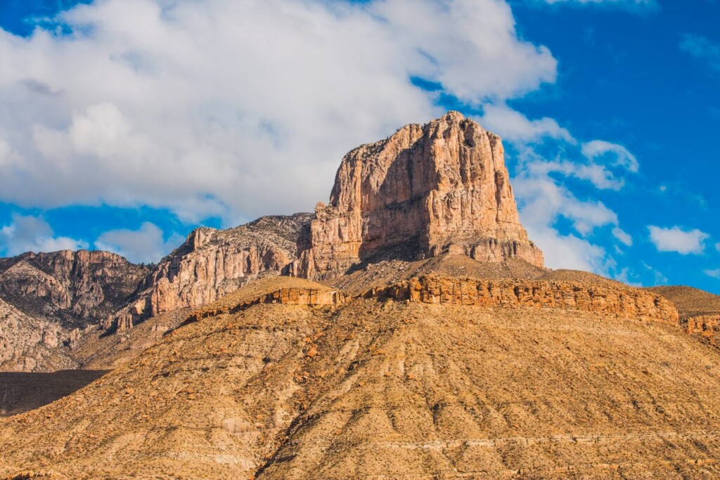 A rocky mountain peak below a bright blue sky