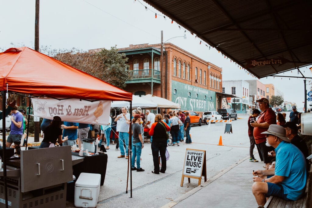 A red tent in the middle of a road surrounded by people in a small town in Texas