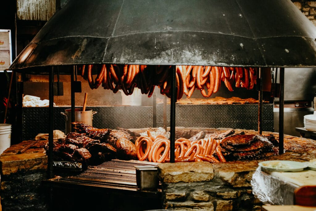 Countless sausage links and briskets on a circular grill