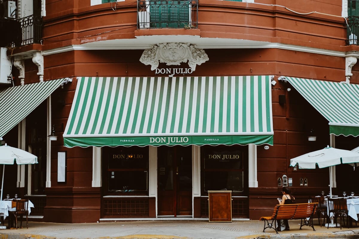 A red street corner with a green and white awning