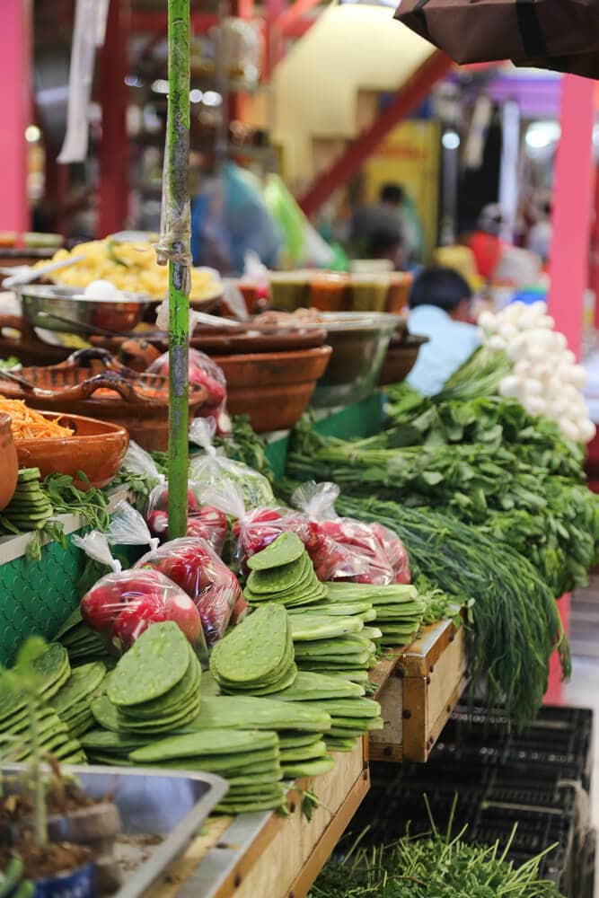 A vegetable stand in Mexico City with nopales, herbs, and peppers