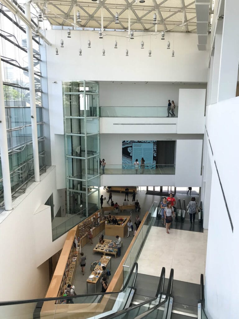 A three story museum with escalators and a bookshop on the ground floor