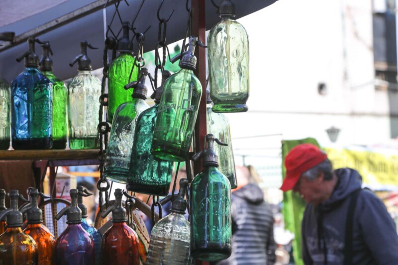 Green soda bottles hang from a booth