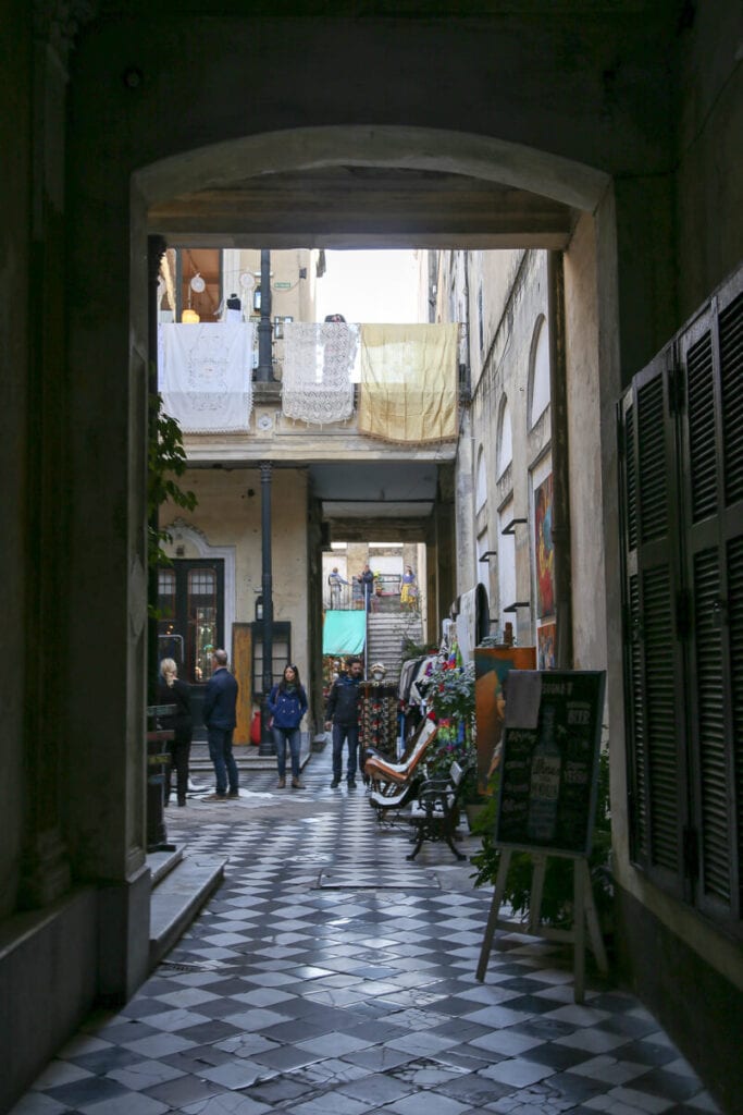 Sheets hang from a balcony in an inner courtyard