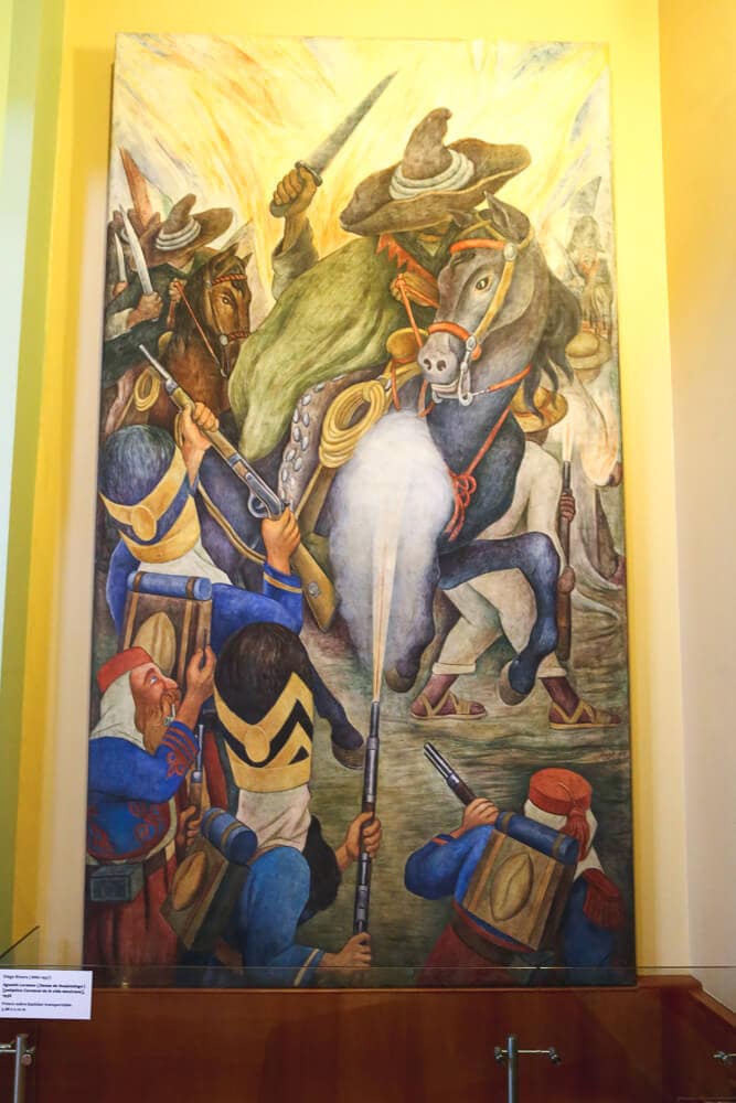 A mural of a man on horseback killing people below