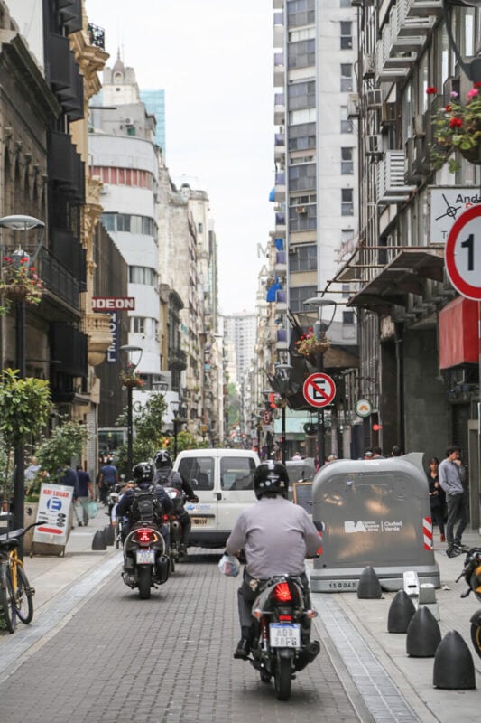 Men on motorcycles on a narrow street 