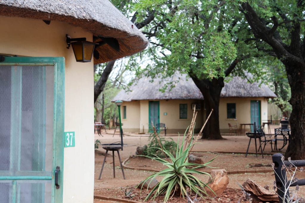 Beige round huts with green doors and grass roofs