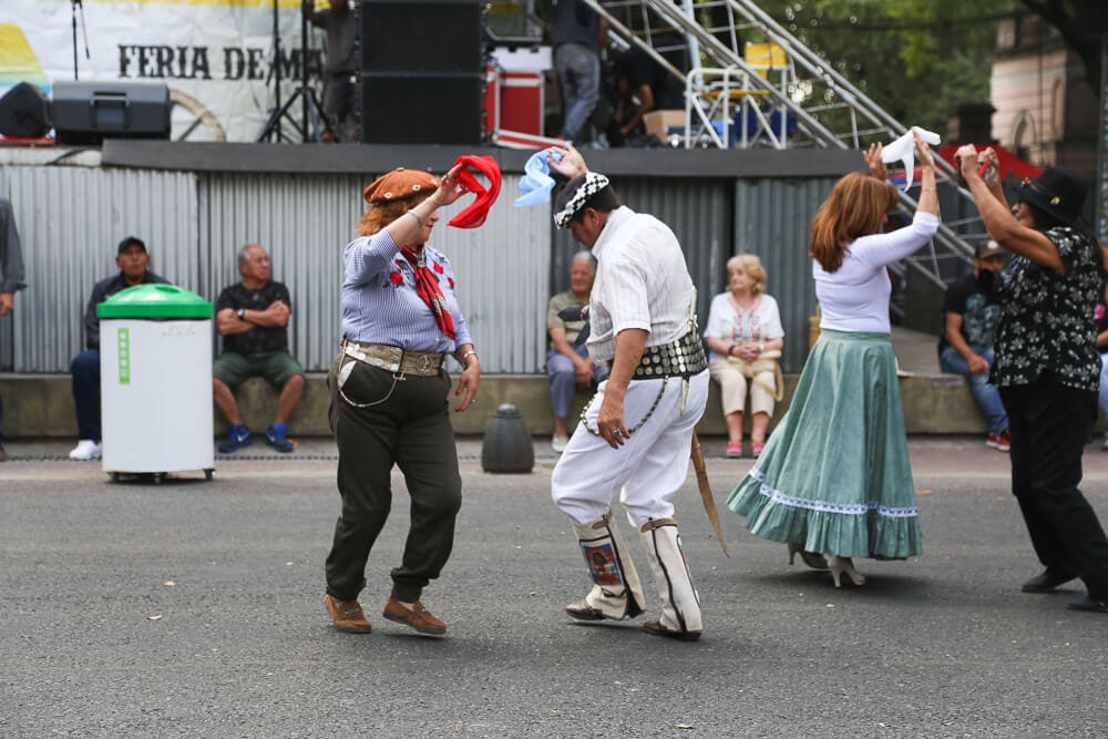 A man and a woman dance twirling handkerchiefs in the air