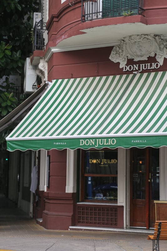 A red building with a green and white awning