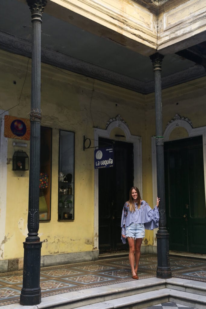 A woman stands in a patio of a historic building