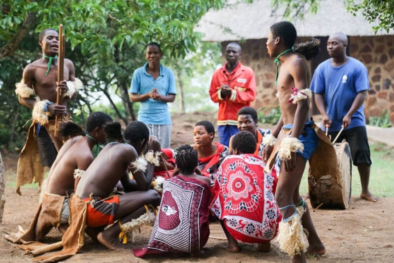 A group of tribal dancers huddle in a circle