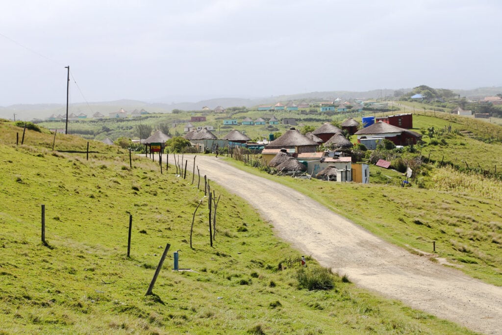 A road leads to a collection of small huts