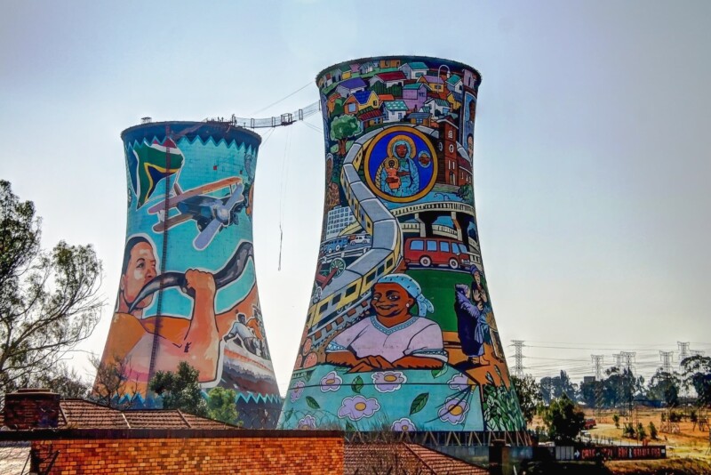 Two huge towers painted in murals with a ladder connecting them