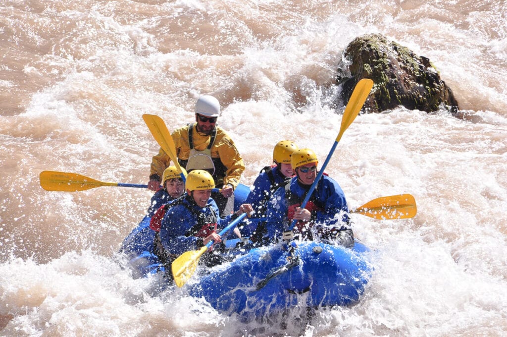 People white water rafting in the rapids