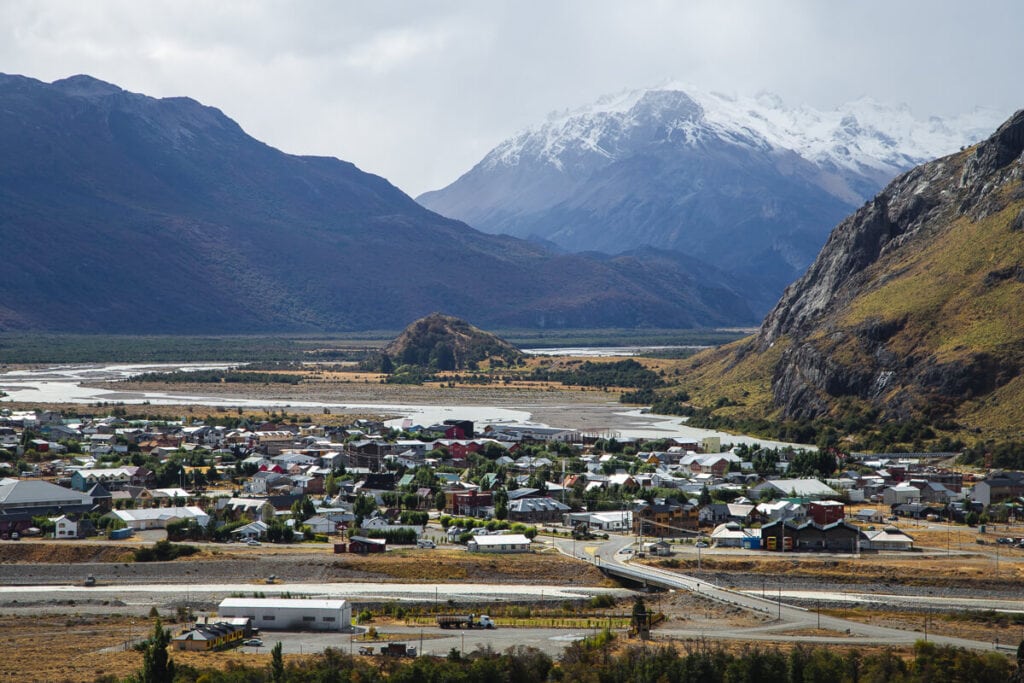 A village in the valley surrounded by snowy mountains