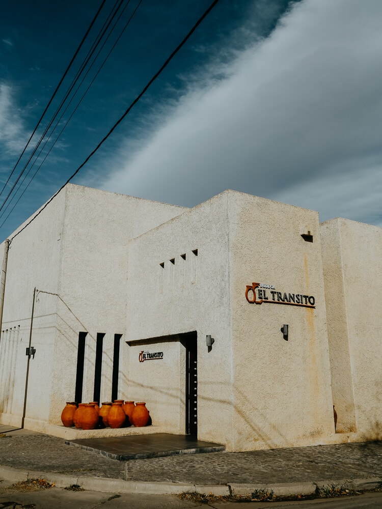 An adobe building with clay pots by the door