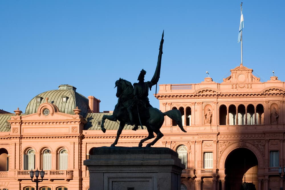 A statue in front of a red government building