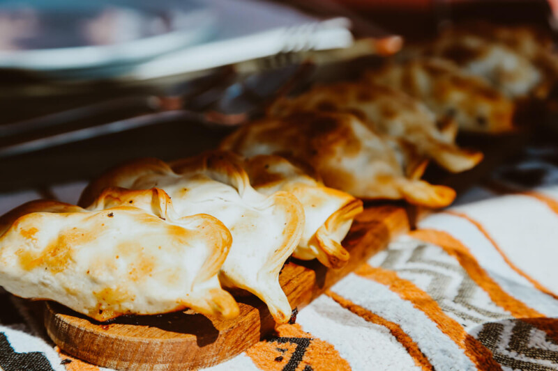 A tray of empanadas on a woven table cloth