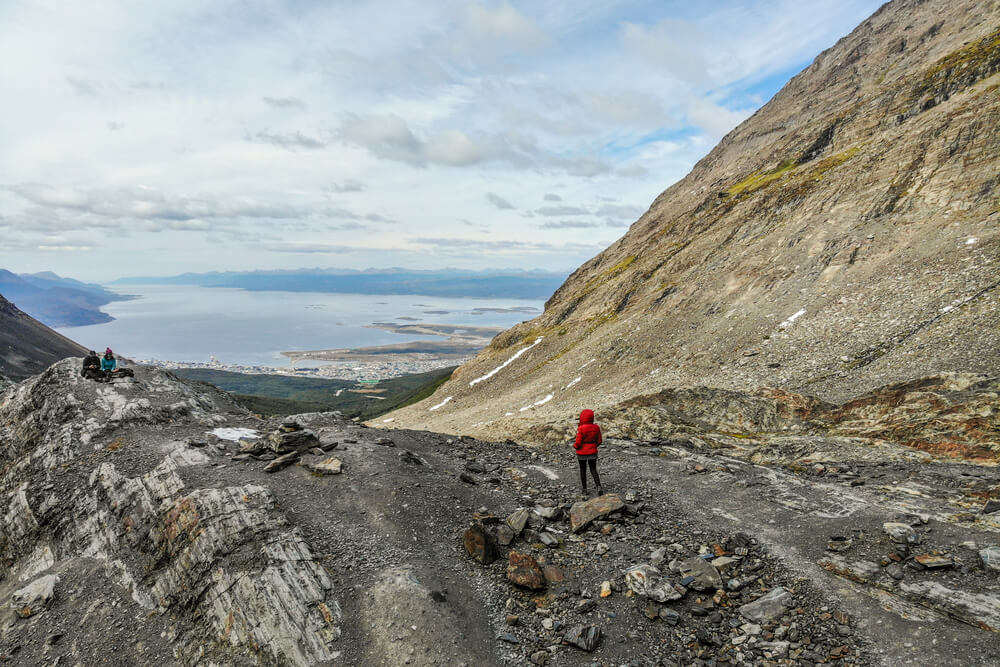 A woman in a red coat on a hiking trail