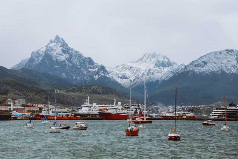 Small fishing boats and large cruise ships in the bay in Ushuaia