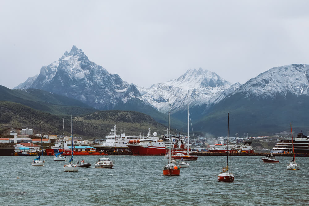 Small fishing boats and large cruise ships in the bay in Ushuaia