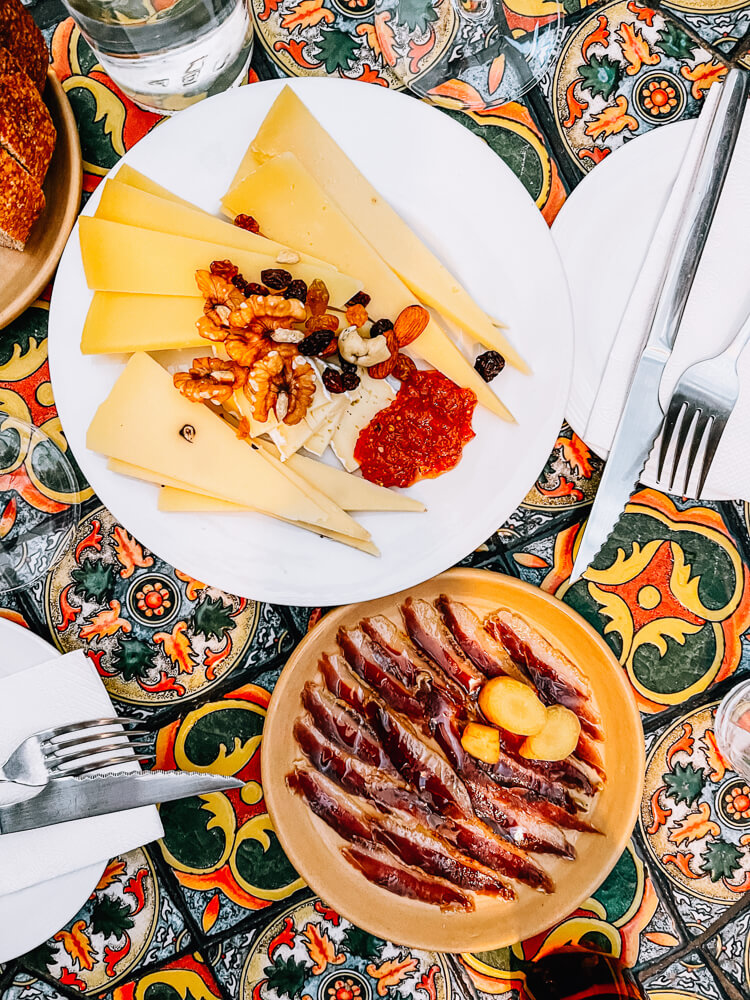 Plates of cheese and cold cuts on a mosaic table