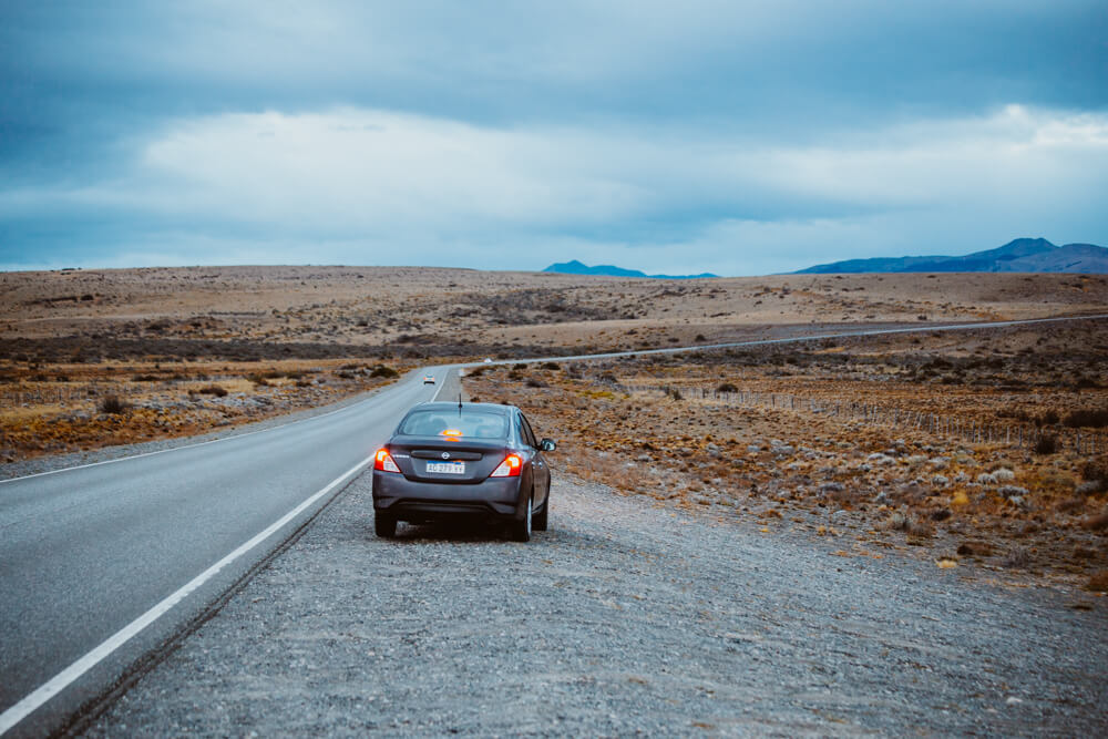 A car driving in Patagonia is pulled over on the side of the road