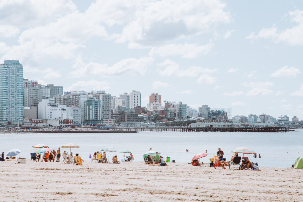 People lounging on the beach with umbrellas in an urban city