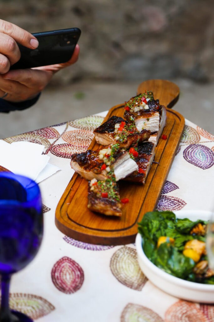 A wooden platter with matambre covered in chimichurri