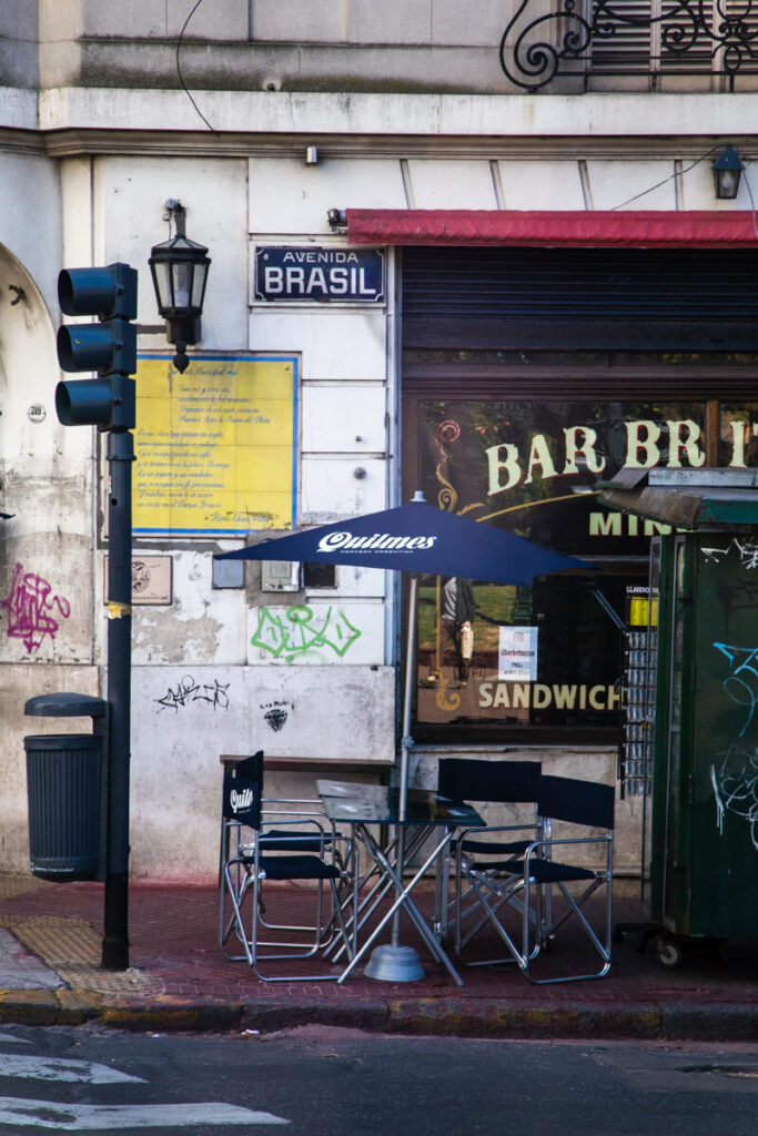 A table with plastic chairs outside a historic bar in Buenos Aires