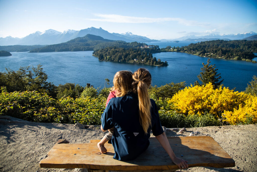 A woman holds her child on a bench at Bariloche's Punto Panoramico