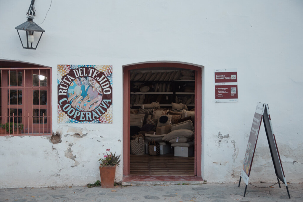 A white stucco building houses a woven coop