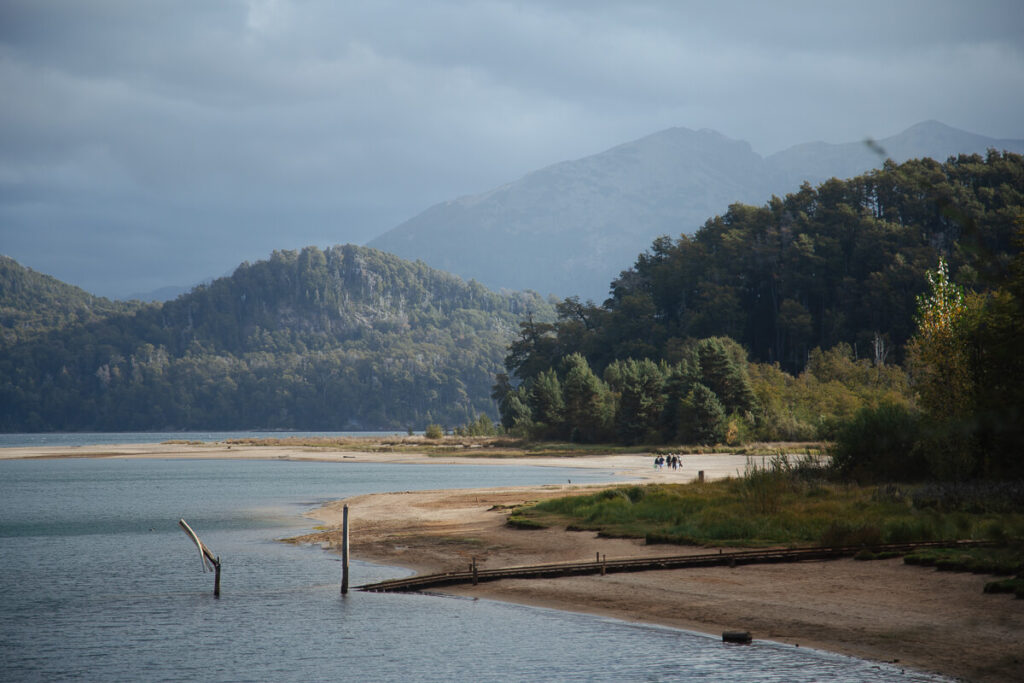 A beach weaves along the bay of the lake in Villa La Angostura